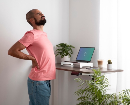 A man with back pain in a home office