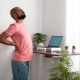 A man with back pain in a home office