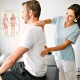 A physiotherapist applying manual therapy to a back man